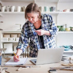 Dueño de pequeña empresa realizando un inventario de productos para optimizar su stock.