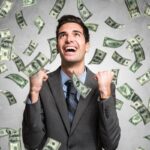 Persona joven celebrando el éxito financiero con billetes y gráficos de crecimiento, simbolizando cómo ser millonario en Perú.