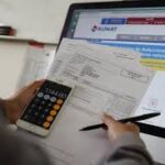 Persona revisando documentos fiscales para la declaración mensual y anual de impuestos en Perú.